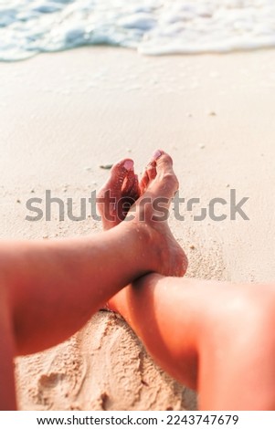 Closeup female feet on white sand beach