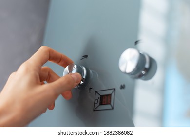 Close-up Of Female Hand Adjusting Temperature Of Water Heater. Modern Home Gas Fired Boiler.