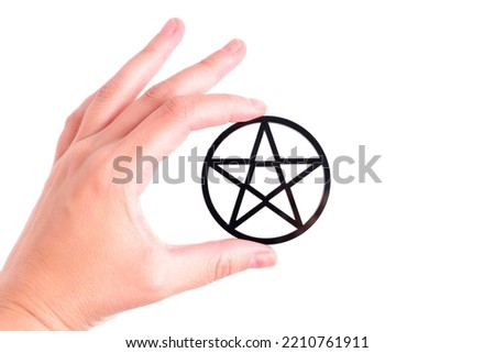 Close-up of a female hand holding a black pentagram isolated on white background