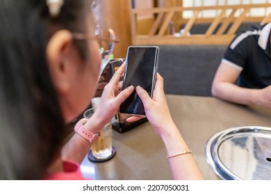 Closeup Of A Female Hand Holding A Smart Phone, Showing Smart Phone With Blank Screen , Black Screen For Mobile App Advertising, Display Mock Up Image