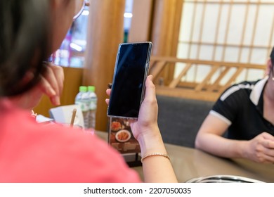 Closeup Of A Female Hand Holding A Smart Phone, Showing Smart Phone With Blank Screen , Black Screen For Mobile App Advertising, Display Mock Up Image