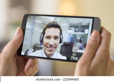 Closeup Of A Female Hand Holding A Smart Phone During A Skype Video