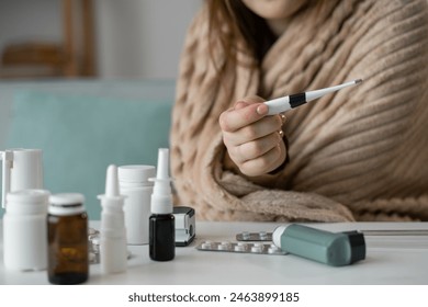 Close-Up of Female Hand Holding Thermometer, Checking Temperature at Home. Woman Monitoring Fever and Health During Illness, Focus on Thermometer Reading in a Cozy Domestic Setting - Powered by Shutterstock