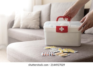 Closeup female hand neatly placing medicament at domestic first aid kit top view. Storage organization in transparent plastic box drug, pill, syringe, bandage. Fast health help safety emergency supply - Shutterstock ID 2144927029