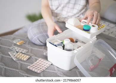 Closeup female hand neatly placing medicament at domestic first aid kit top view. Storage organization in transparent plastic box drug, pill, syringe, bandage. Fast health help safety emergency supply - Shutterstock ID 2179866057