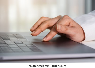 close-up female hand touching touchpad on a laptop computer