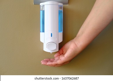 Closeup of Female hand using alcohol gel disinfecting hands. Cleaning Hands. Washing hands using automatic sanitizer dispenser.  