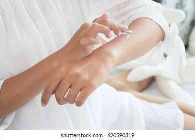 Closeup of female hands applying cream on her arm. Make up, healthy skin, beauty shot, cute asian woman concept