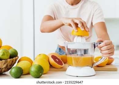 Closeup of female hands and citrus juicer during fresh orange juice preparation