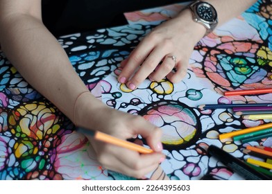 Close  up female hands drawing neurographic art  Mental health  adult fine motor skills  creativity  psychology  Abstract neurographic drawing and marker  colored pencils  Art  selective focus  