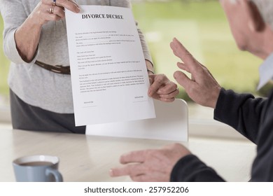 Close-up Of Female Hands Holding Divorce Paper