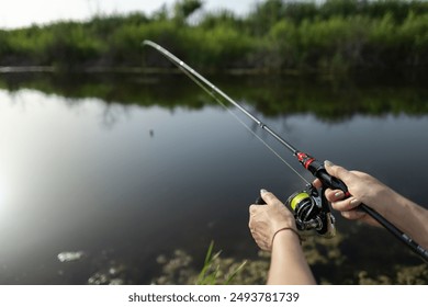 Closeup of a female hands holding a fishing rod and reel. - Powered by Shutterstock