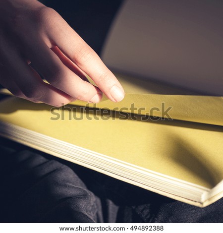 Close-up of female hands holding open book. Woman reading book.