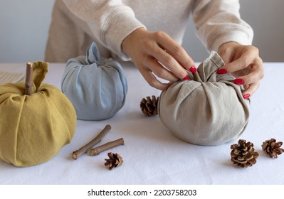 closeup of female hands making fabric pumpkins. Thanksgiving and Halloween decoration. Furoshiki gifts - Shutterstock ID 2203758203