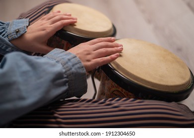 Close-up of female hands on mini bongo drums. The girl plays a traditional ethnic percussion instrument - Powered by Shutterstock