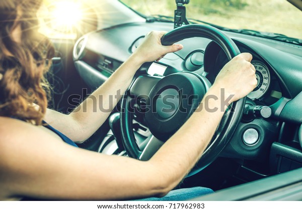 Closeup of female hands on the\
steering wheel in the car. The concept travel and road\
mood