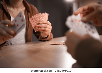 Close-up of female hands with playing cards. People playing card game at home. Copy space - Powered by Shutterstock