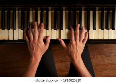 Closeup of female hands playing the piano, view from the top