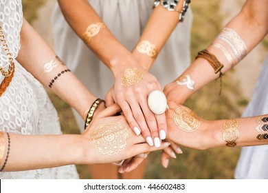 Close-up of female hands, three girls, best friends, flash tattoo, accessories, Bohemian, bo-ho style, indie hippie, ring, bracelet, manicure - Powered by Shutterstock