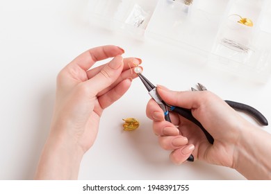 Close-up of female hands. Woman work with jewelry tools on white backgrpound. Jewelry designer working in studio with tools making pearl earrings.  - Powered by Shutterstock