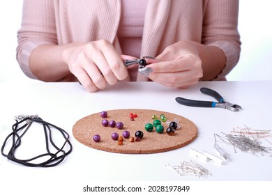 Close-up Of Female Hands. Woman Work With Jewelry Tools On White Backgrpound. Jewelry Designer Working In Studio With Tools Making Jewerly. 