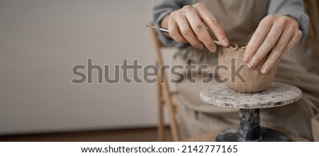 Close-up of female hands working with clay. the potter makes dishes and other handicrafts. Ceramics. Hobby and leisure concept, copy space.