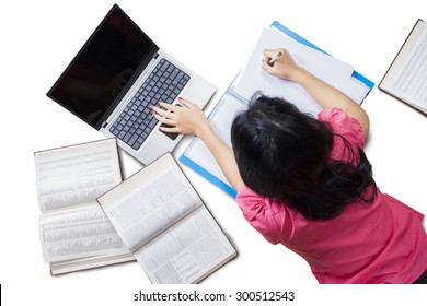 Closeup Of Female High School Student Lying Down On The Floor While Doing Her Homework With Laptop And Books, Isolated On White