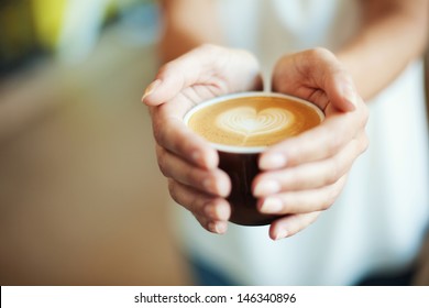 Closeup of Female holding coffee with heart symbol - Powered by Shutterstock