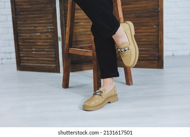 Close-up of female legs in black jeans in stylish leather beige shoes. Fashionable woman in new loafers. Modern seasonal collection of stylish shoes. Women's fashion.