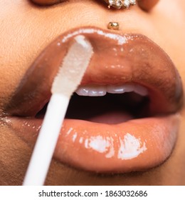 Closeup Of Female Lips Applying Lip Gloss With An Applicator