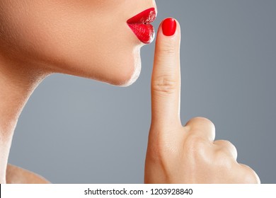 Close-up Of Female Lips With Finger. Shush Or Silence Gesture