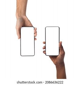 Closeup of female and male hands holding 2 smartphones with white empty screen, showing using devices, transfer data, sharing media. Two vertical gadgets with copy space, mock up, studio background - Shutterstock ID 2086636222