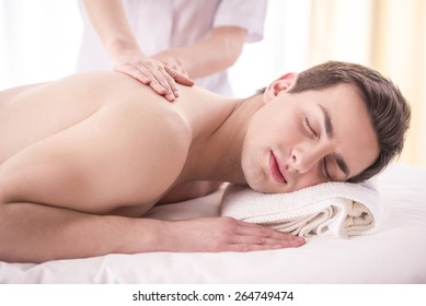Close-up. Female masseur doing massage on male in the spa salon.