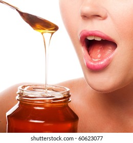 closeup of female mouth and spoon with honey