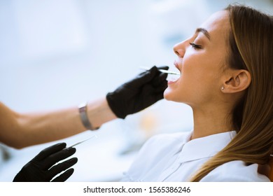 Close-up of female with open mouth during oral checkup at the dentist office - Shutterstock ID 1565386246