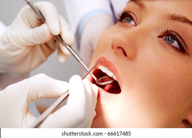 Close-up of female patient having her teeth examined by specialist - Powered by Shutterstock