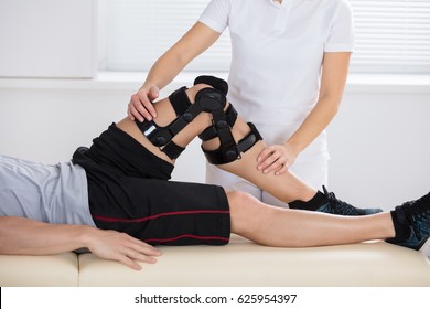 Close-up Of A Female Physiotherapist Giving Leg Exercise In Clinic