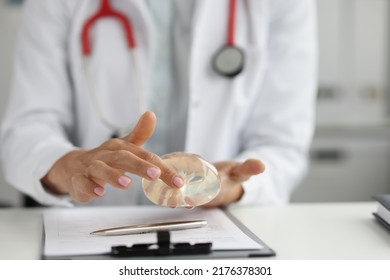 Close-up Of Female Plastic Surgeon Touching Silicone Implant With Finger. Plastic Surgery And Breast Augmentation Concept