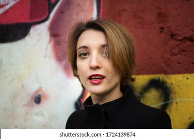 Close-up Female Portrait Of Young Smiling Girl With Short Blonde Hair Near The Wall With Graffiti. Youth Culture, Street Art Concept