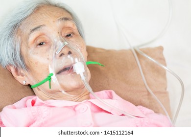 Closeup Of Female Senior Patient Putting Inhalation Or Oxygen Mask In Hospital Bed Or Home,sick Elderly Asian Woman Undergoing Treatment With Best Medicine,healthcare Concept