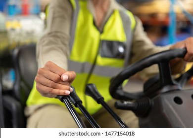 Close-up of female staff driving forklift in warehouse. This is a freight transportation and distribution warehouse. Industrial and industrial workers concept - Powered by Shutterstock