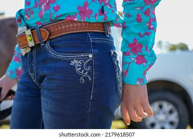 Closeup Of Female Wearing Western Style Jeans, Leather Belt And Floral Pattern Shirt