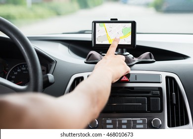 Close-up Of Female's Hand Using GPS Navigation Inside Car
