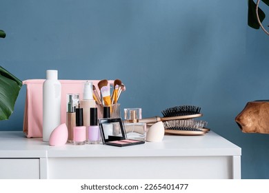 closeup of feminine cosmetic products standing on vanity table, nail polish and face powder