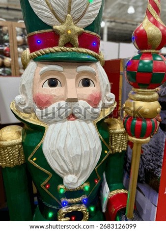 Close-up of a festive nutcracker figure with painted face, white beard, red cheeks, and colorful uniform details.