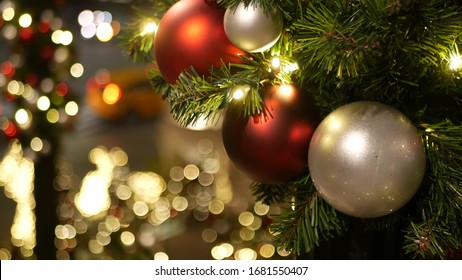 Closeup of Festively Decorated Outdoor Christmas tree with bright red balls on blurred sparkling fairy background. Defocused garland lights, Bokeh effect. Defocused night city street, cars on road. - Shutterstock ID 1681550407