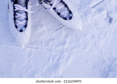 Close-up Of Figure Skates On An Ice Background. Ice Skating Outdoor Activities With The Family In Winter.Legs Of Ice Skater With Start Sign On The Ice Rink, View From Above