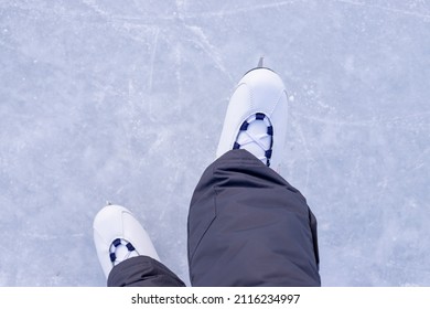 Close-up Of Figure Skates On An Ice Background. Ice Skating Outdoor Activities With The Family In Winter.Legs Of Ice Skater With Start Sign On The Ice Rink, View From Above