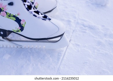 Close-up Of Figure Skates On An Ice Background. Ice Skating Outdoor Activities With The Family In Winter.Legs Of Ice Skater With Start Sign On The Ice Rink, View From Above