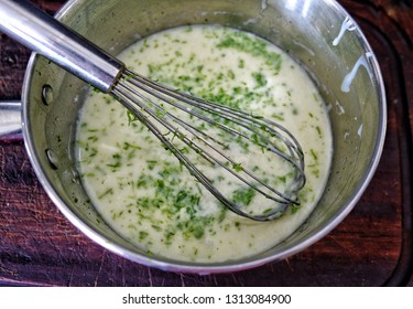 Closeup Of Filling For Key Lime Pie In Pot With Whisk And Grated Green Lime Zesy On Filling. Shot From Above